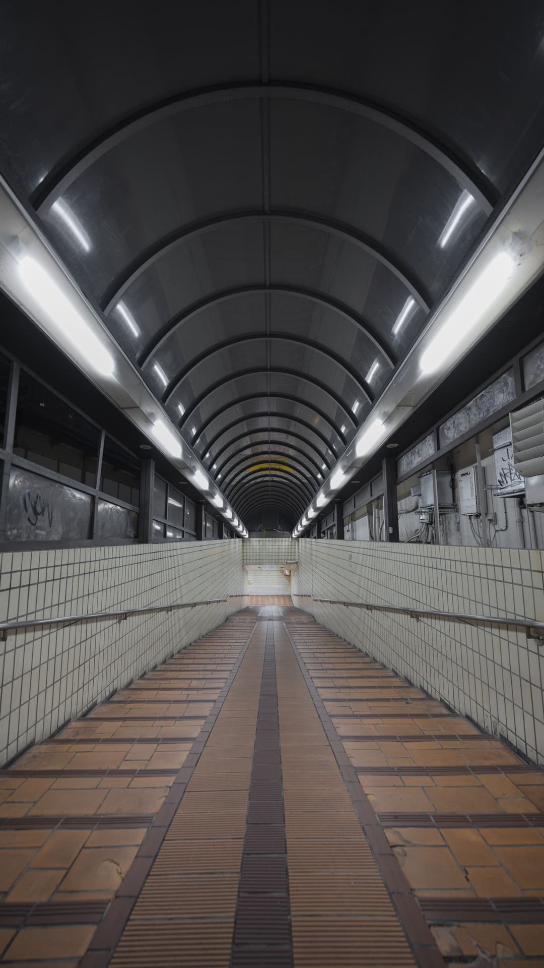 Deretan lampu LED linear di atap terowongan koridor stasiun