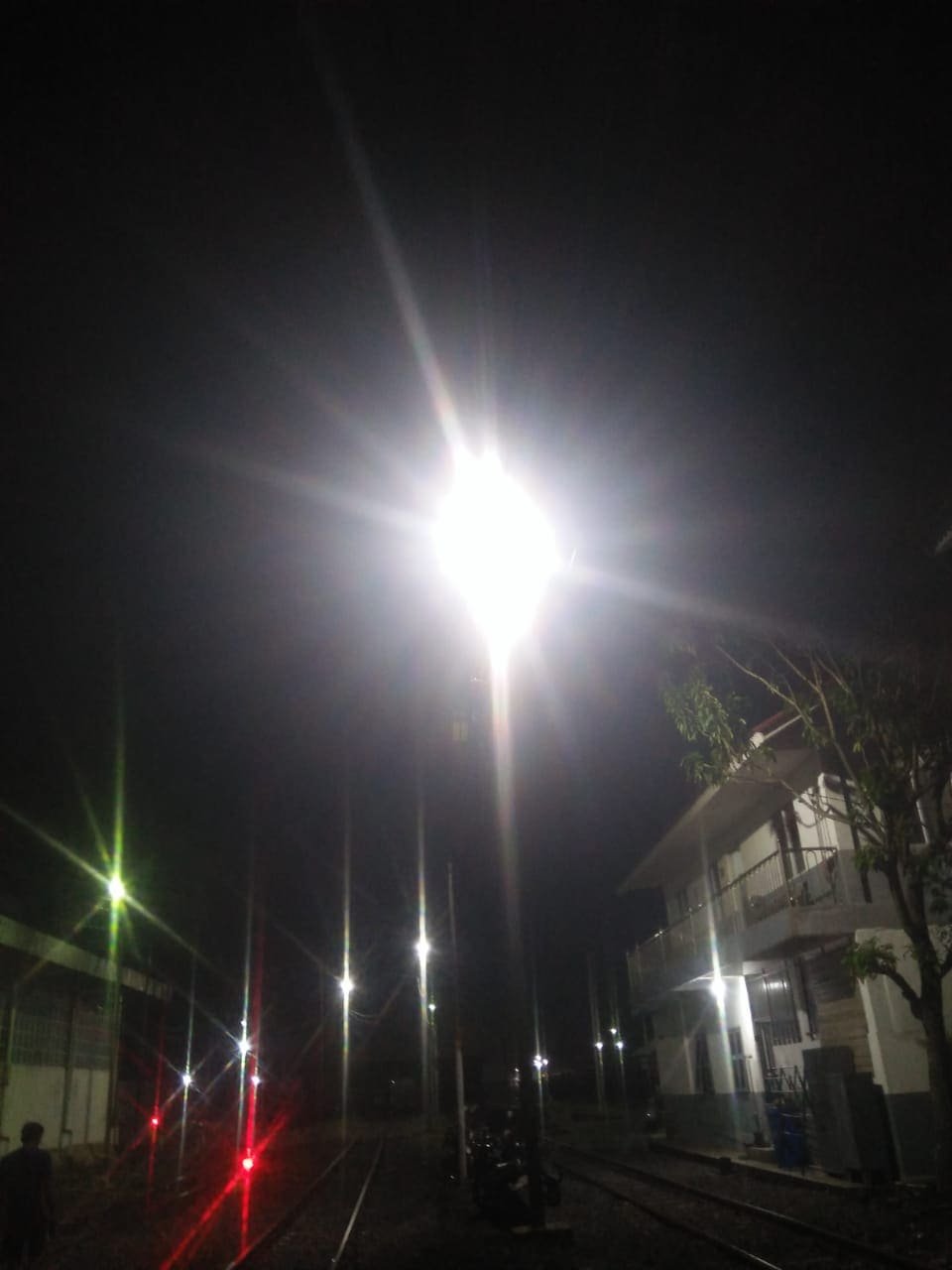 Lampu LED industrial dipasang pada tiang tinggi di area stasiun